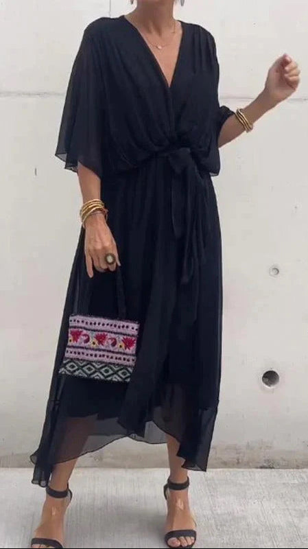 Black dress with embroidery at the bottom worn by a person against a plain background