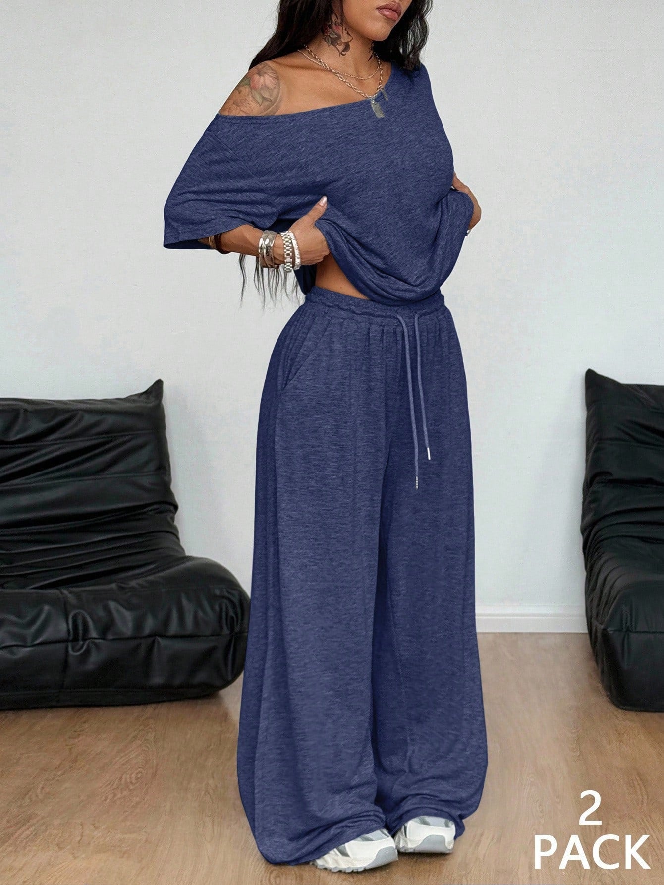 Woman wearing a blue off-shoulder top and wide-leg pants with text '2 Pack' on a white background.