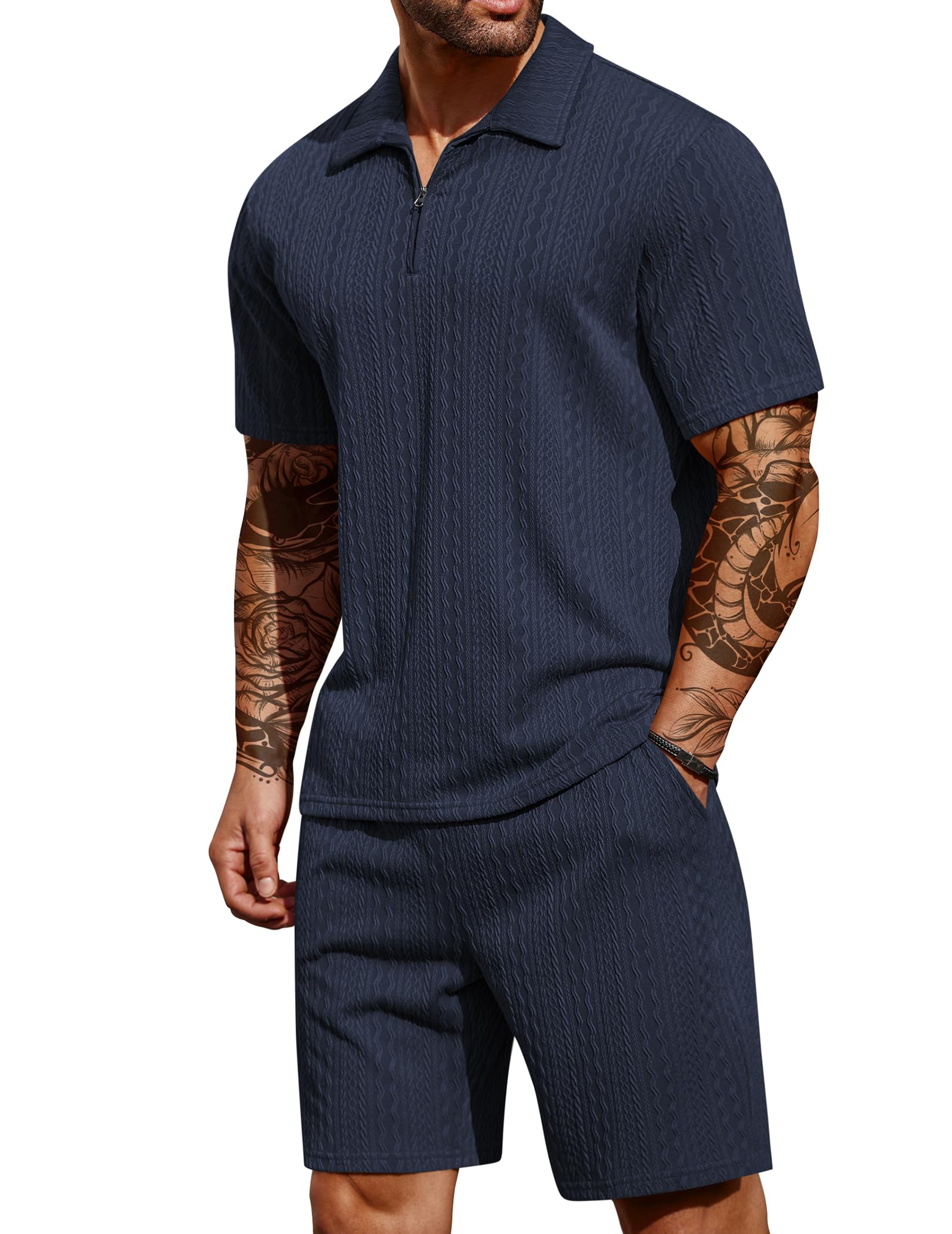 Man wearing a navy blue ribbed polo shirt and shorts set on a white background