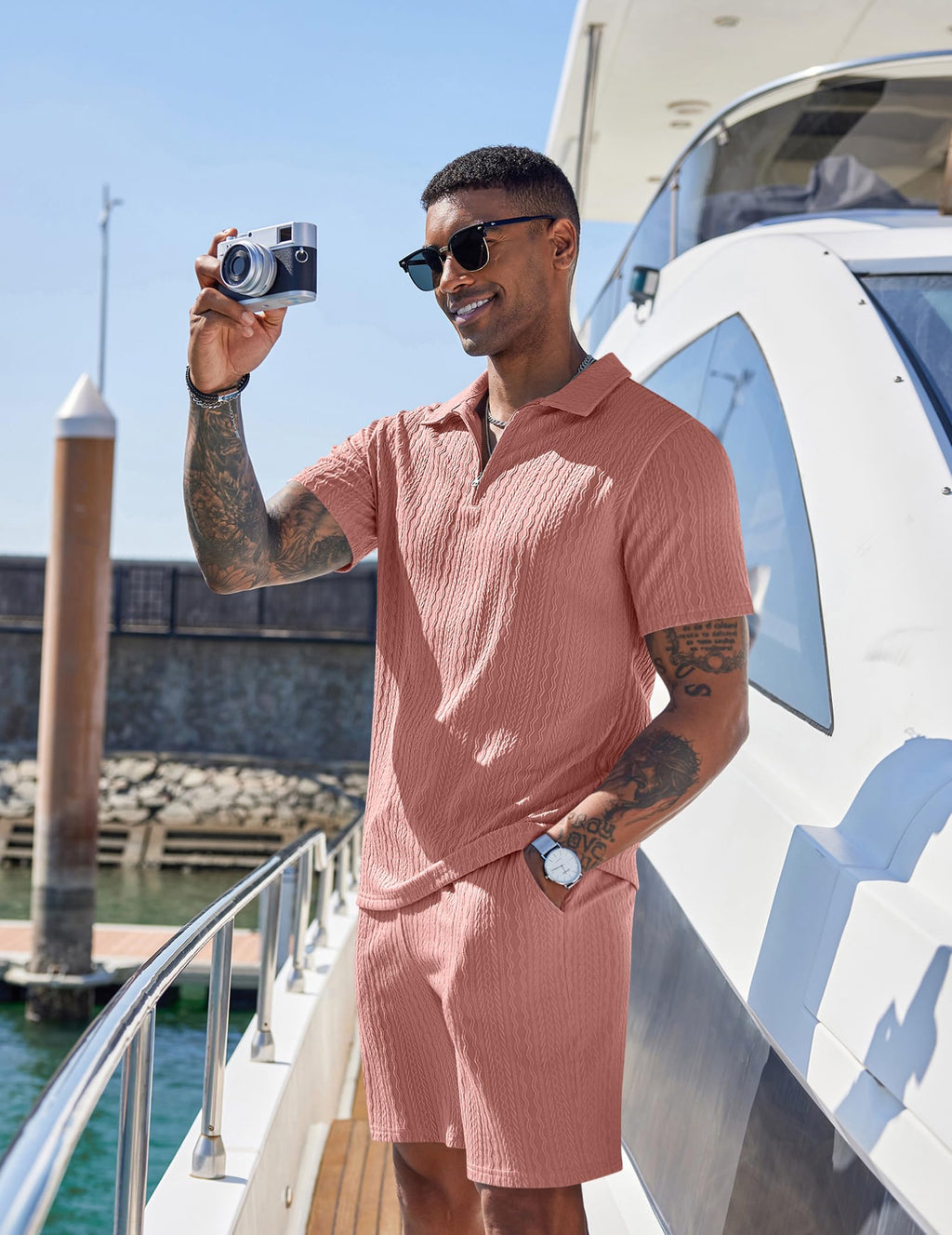 Man in a pink outfit taking a selfie on a boat