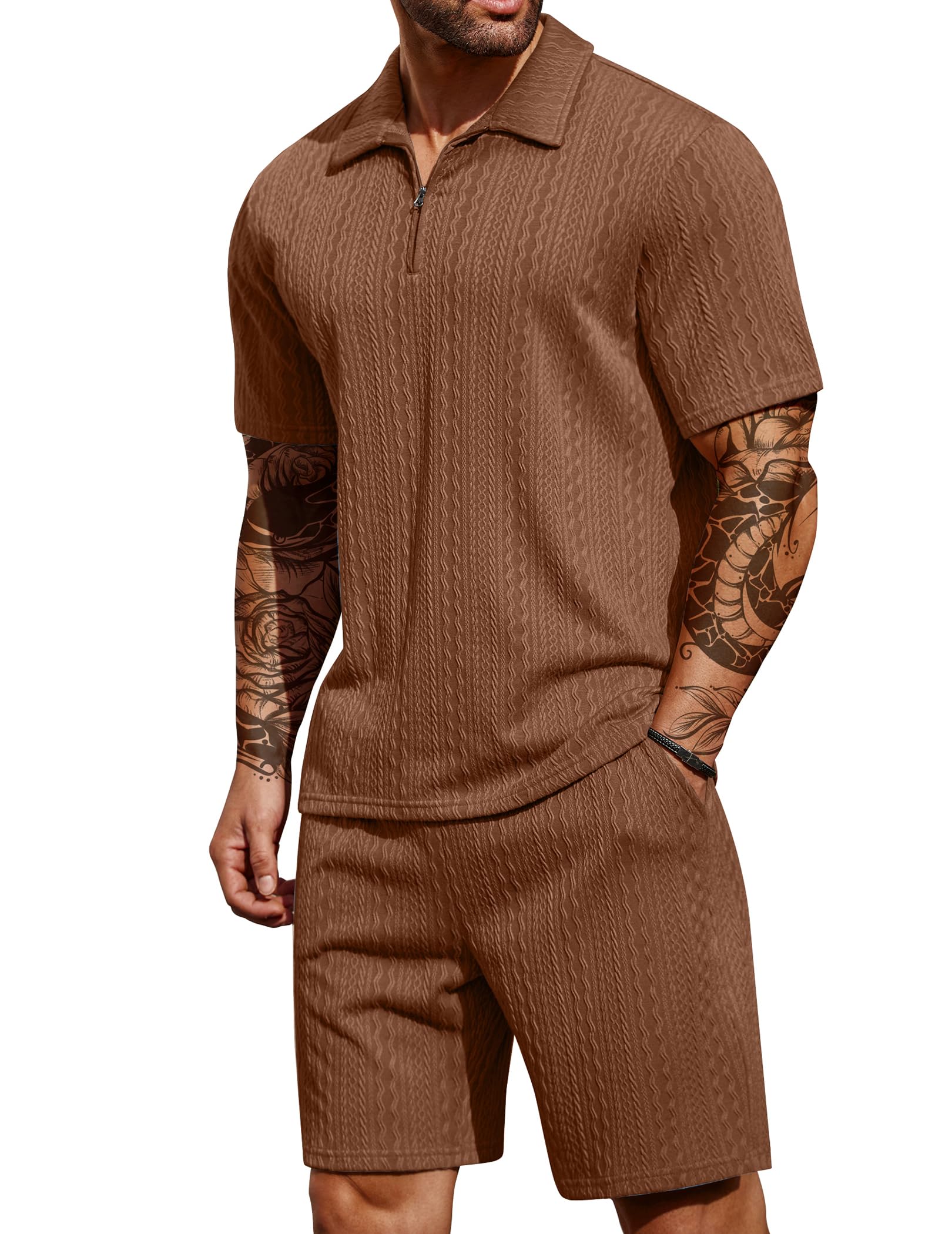 Man wearing a brown ribbed knit outfit with tattoos on arms against a white background