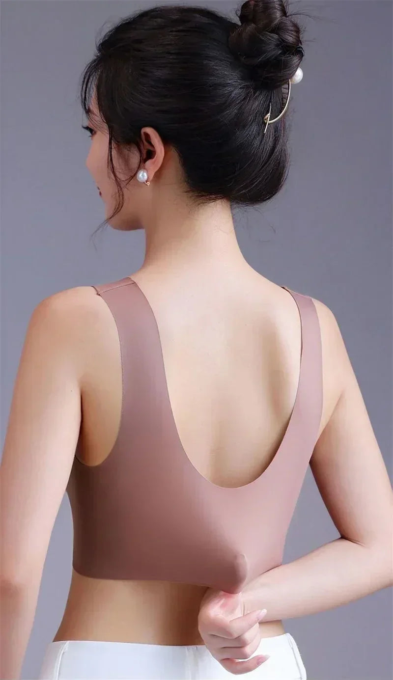 Woman wearing a beige sports bra against a gray background