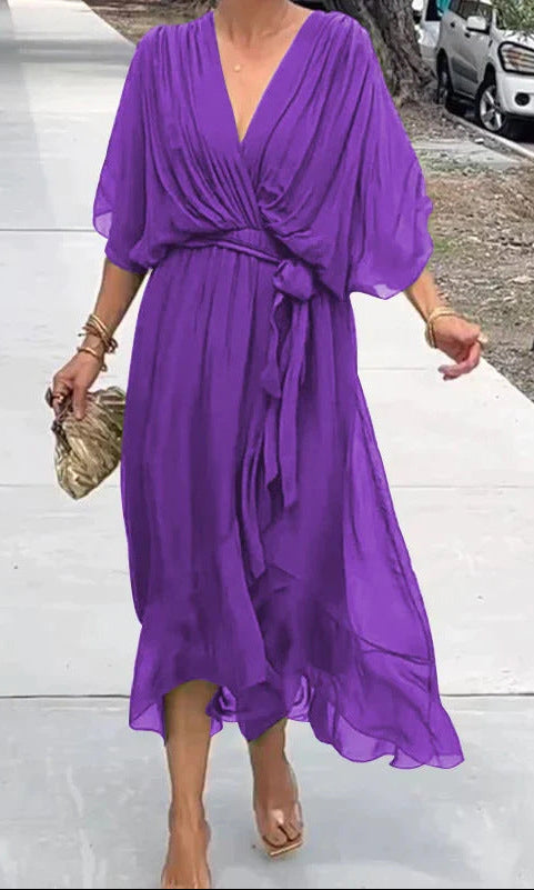 Person wearing a purple dress on a sidewalk.