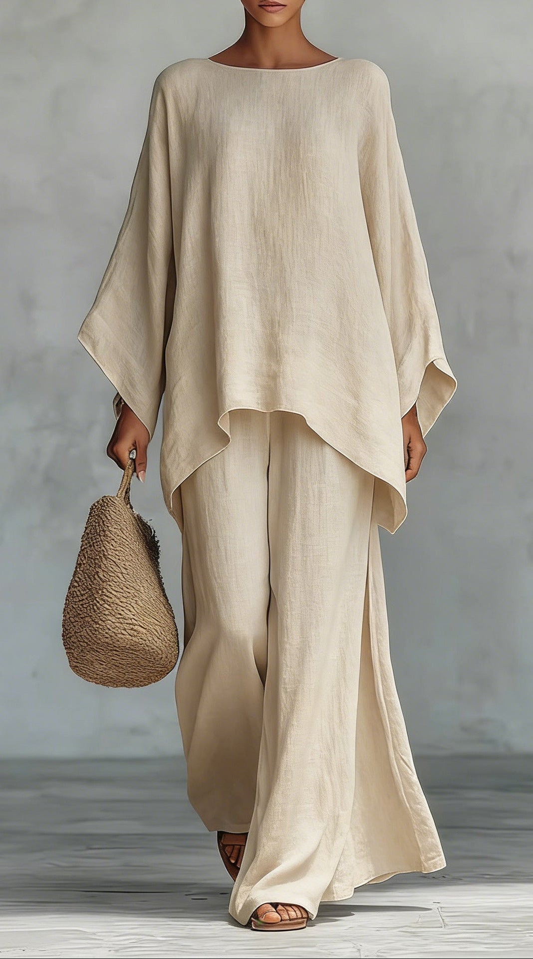 Person wearing a beige outfit holding a woven bag against a gray background