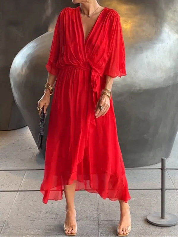 Red dress worn by a person in an indoor setting with a large metallic sculpture.