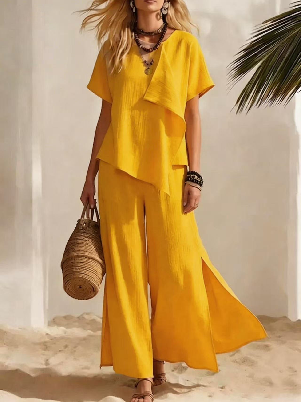 Woman in a yellow outfit holding a woven bag on a beach.