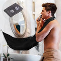 Man shaving with a black electric razor in a bathroom setting.